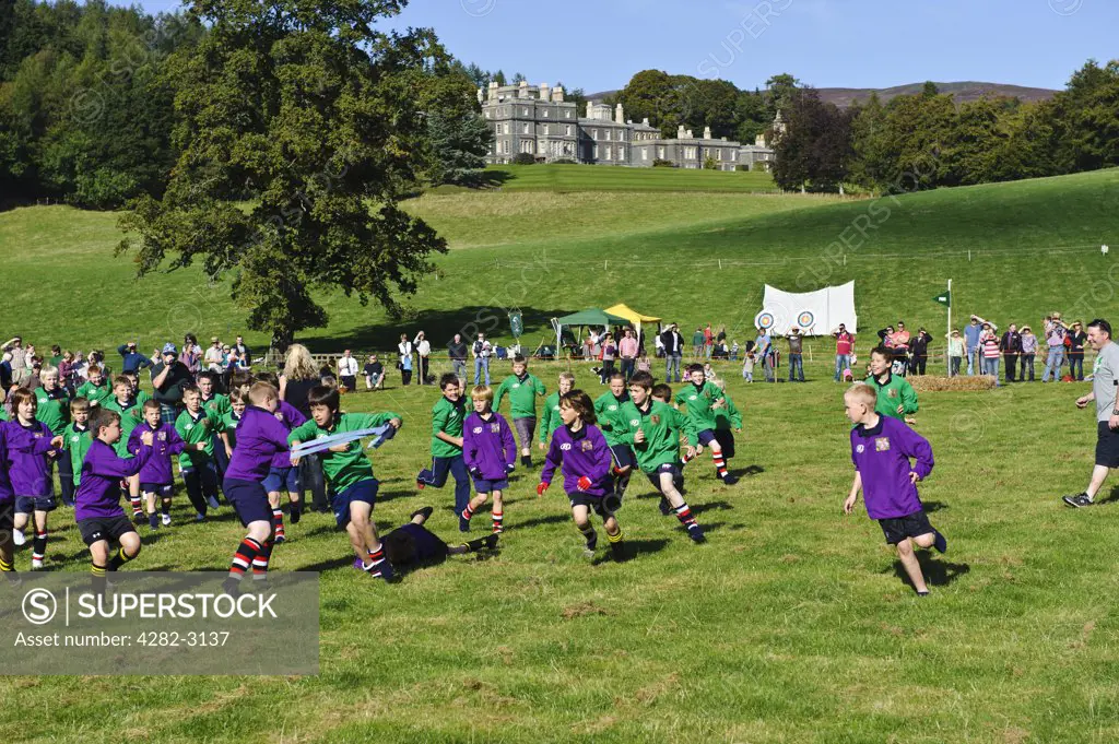 Scotland, Scottish Borders, Bowhill House. Children taking part in a re-enactment of the famous Caterhaugh BaÄö?Ñ?¥ game of 1815 at The Muster, a regional gathering of Lowland and Border Clans on Buccleuch Estate, Selkirk.