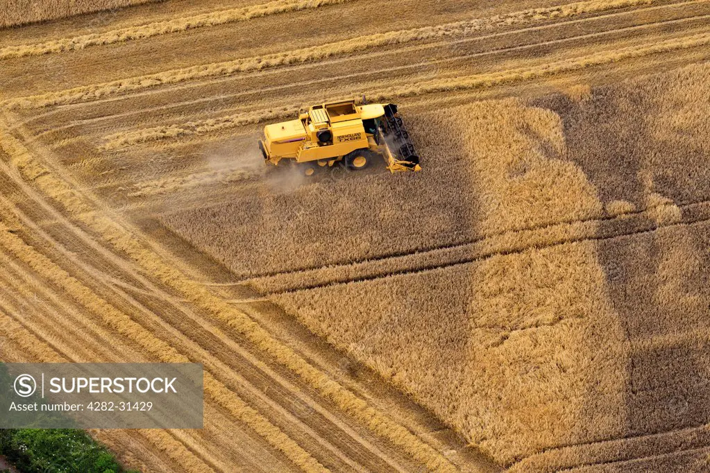 England, Berkshire, Bray. Aerial view of a combine harvester at work.