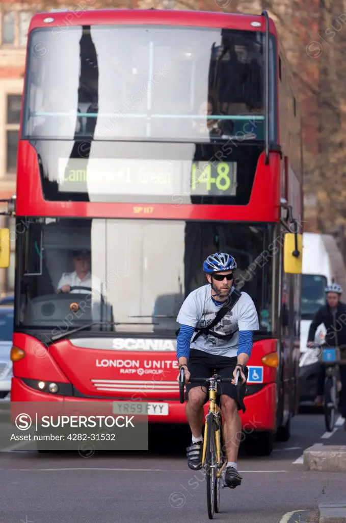 England, London, Westminster. A cyclist and a bus in Parliament Square in London.