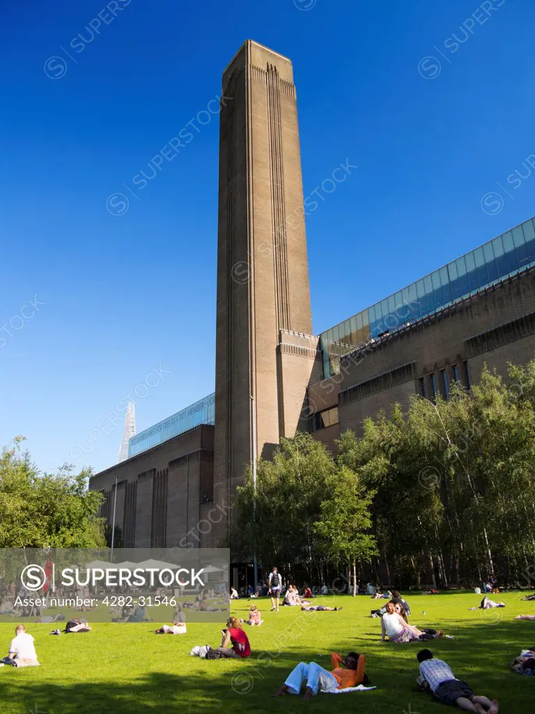 England, London, Millbank. People enjoying a summer day in front of the Tate Modern gallery in London.