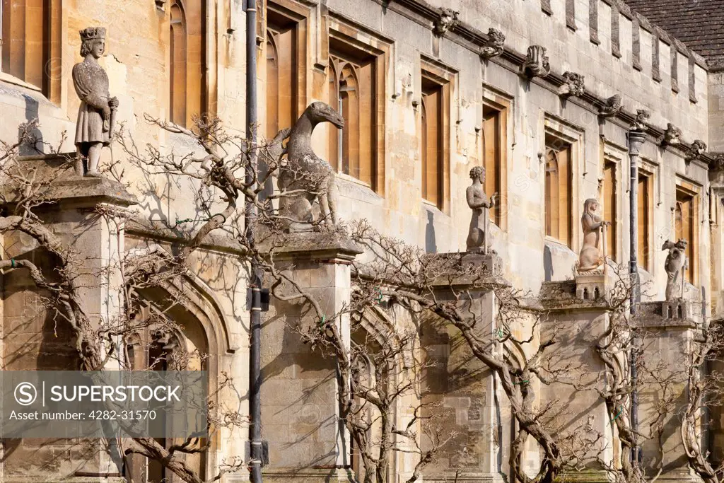 England, Oxfordshire, Oxford. The Cloister of Magdalen College in Oxford with statues and wisteria.
