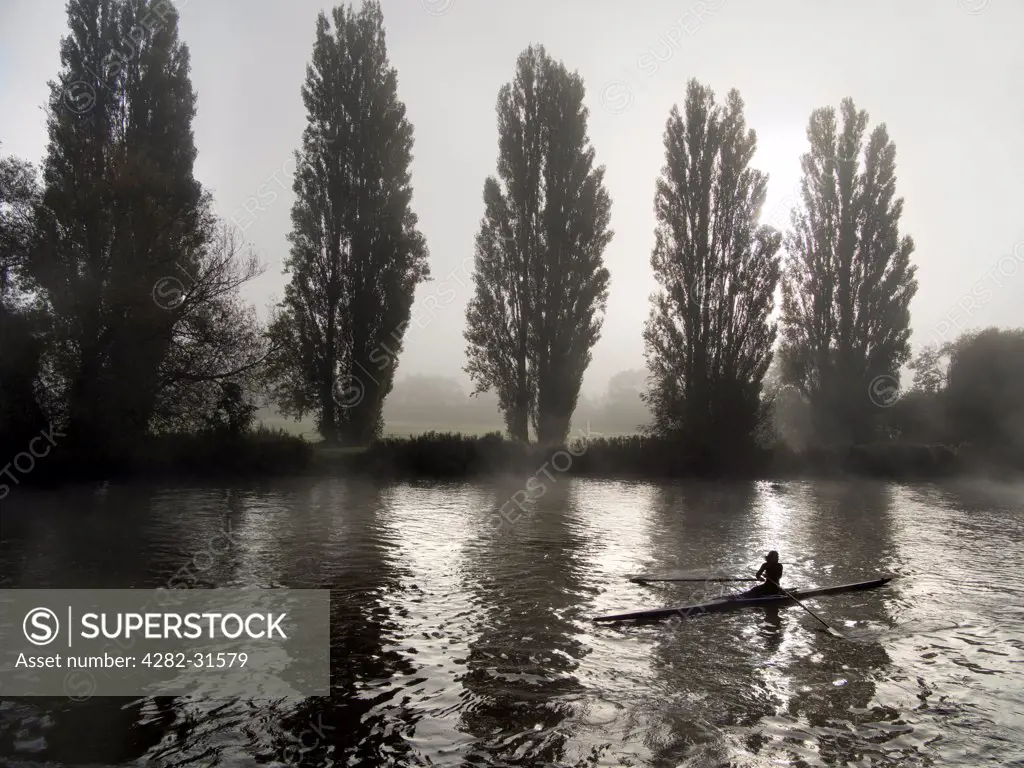 England, Oxfordshire, Abingdon. A rower on a misty morning near to Saint Helen's wharf in Abingdon on Thames.