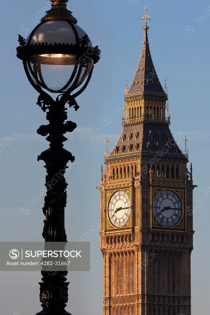England, London, Westminster. Big Ben and ornate lamppost at dusk.
