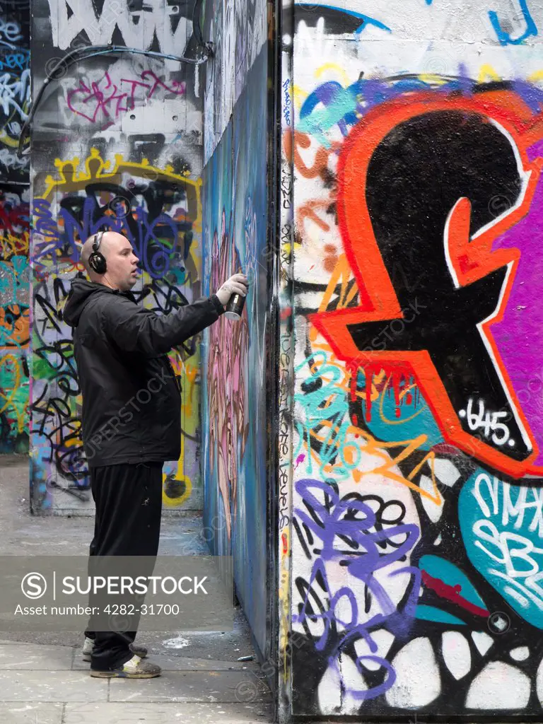 England, London, South Bank. Man spraying at graffiti-land on the South Bank in London.