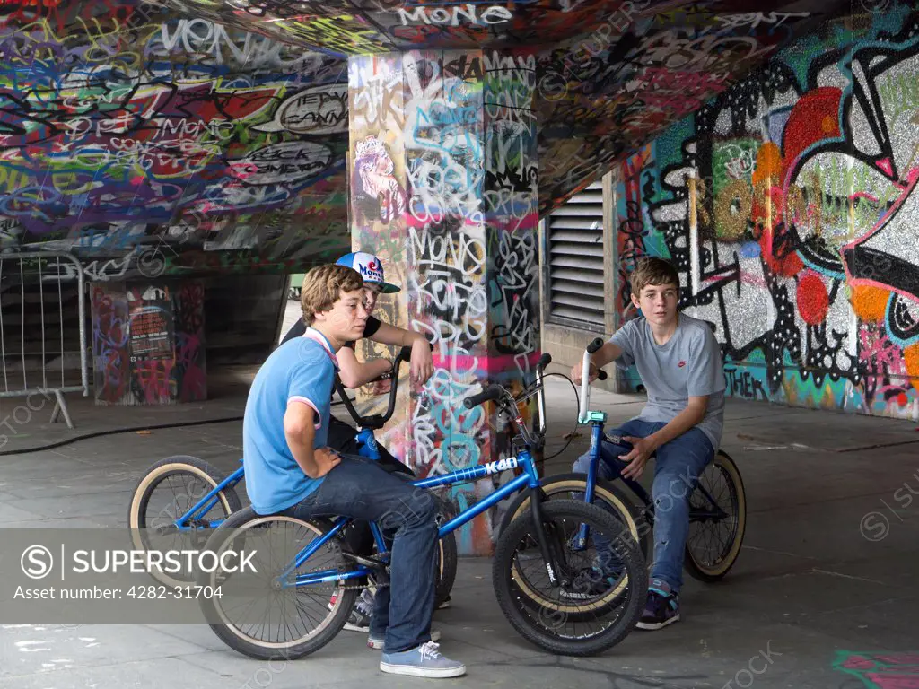 England, London, South Bank. Three cyclists at at graffiti-land on the South Bank in London.
