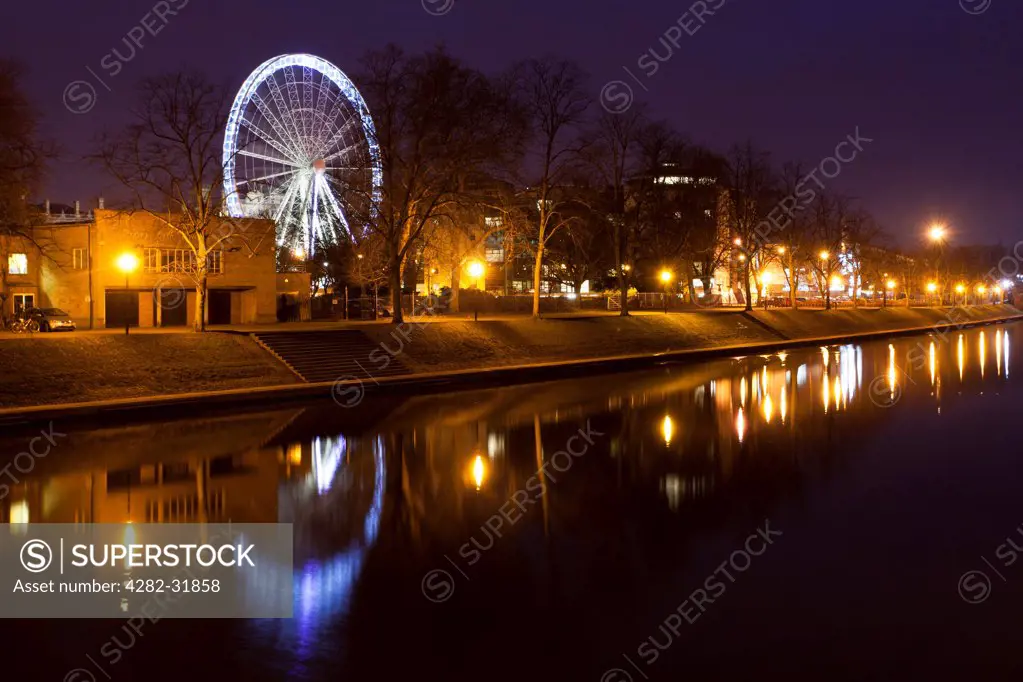 England, North Yorkshire, York. York Eye ferris wheel reflected at dusk in the still waters of the River Ouse.