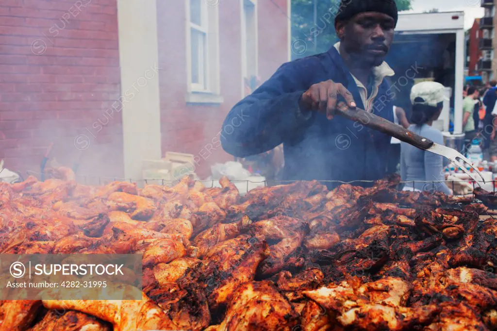 England, Bristol, St Paul's. Barbecuig jerk chicken during St Paul's carnival in Bristol.