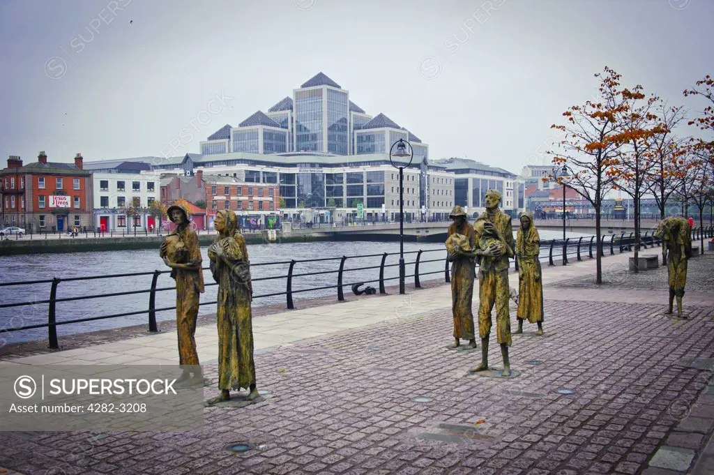 Ireland, Dublin, Dublin. Famine memorial statues on Custom House Quay, Dublin, designed and crafted by Dublin sculptor Rowan Gillespie. Ulster Bank Group headquarters in the background.