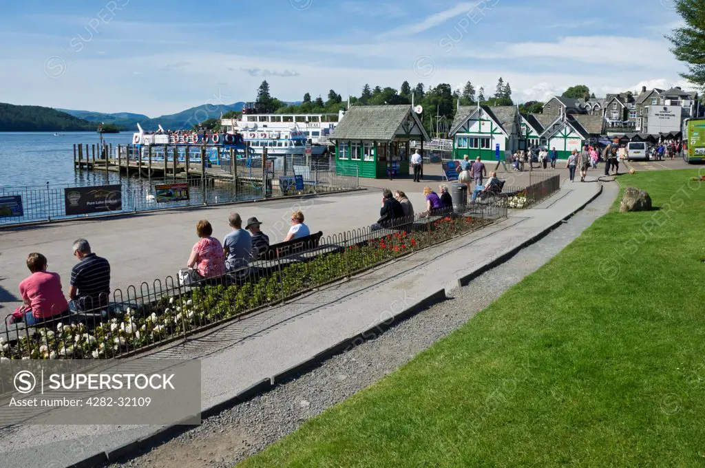 England, Cumbria, Bowness on Windermere. Visitors on the promenade overlooking Lake Windermere.