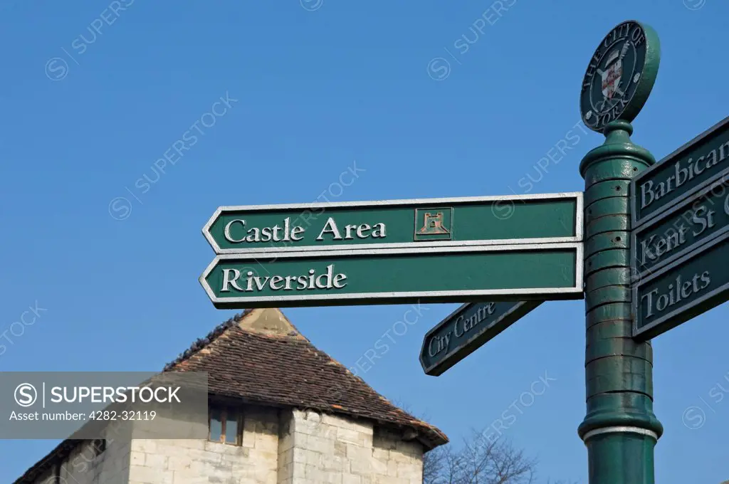 England, North Yorkshire, York. A tourist information signpost with Fishergate Postern in the background.