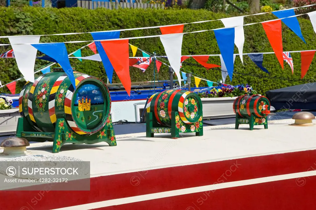 England, North Yorkshire, Skipton. Traditional hand-painted barrels on board a narrow boat.