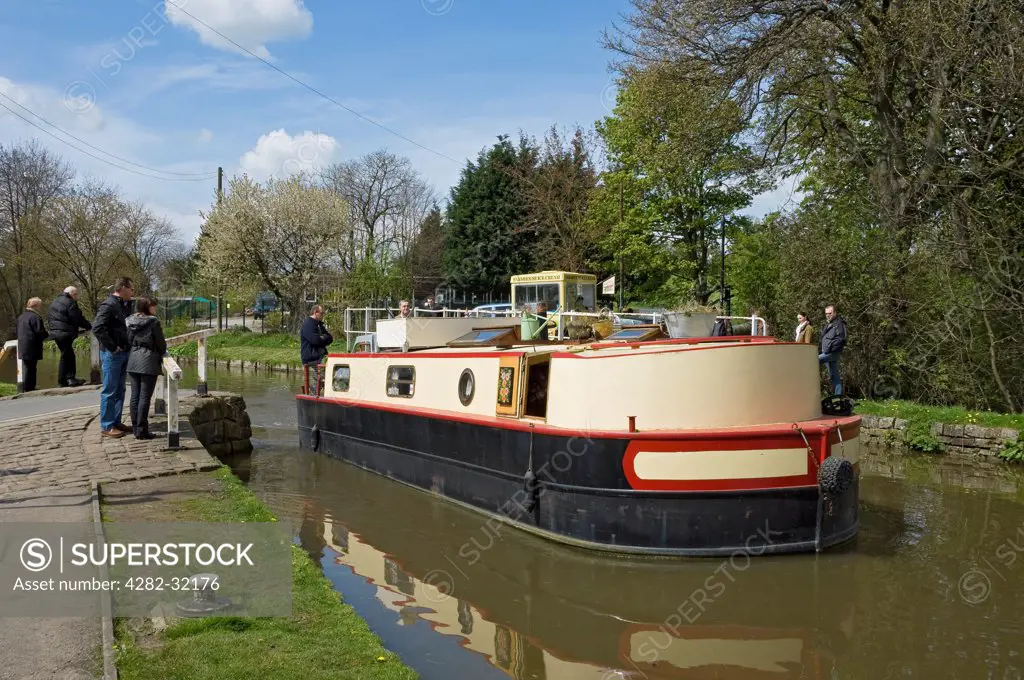 England, North Yorkshire, Skipton. Narrow boat passing through a swing bridge on the Leeds and Liverpool canal near Skipton.