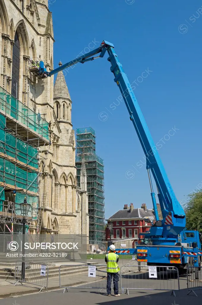 England, North Yorkshire, York. Workers inspecting stonework on the South Transept of York Minster.