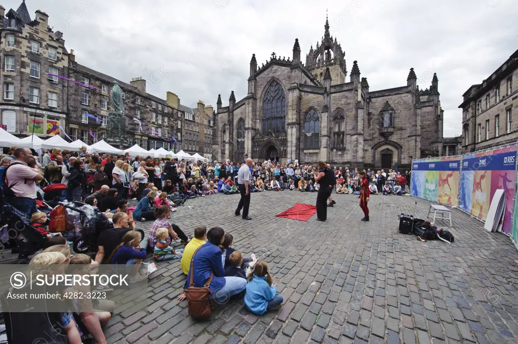 Scotland, City of Edinburgh, Edinburgh. Performers entertaining a large crowd on the High Street during the Fringe at the Edinburgh Festival.
