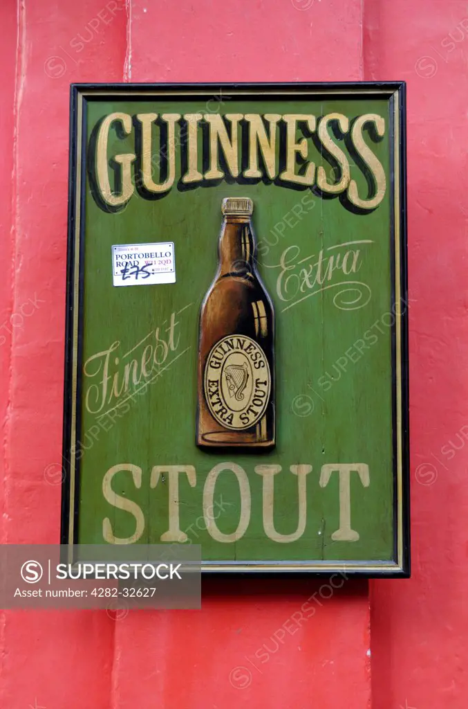 England, London, Portobello Road. An antique Guinness Stout sign for sale in Portobello market.