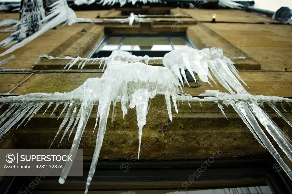 England, Gloucestershire, Stow on the Wold. Icicles hanging from a pub window.