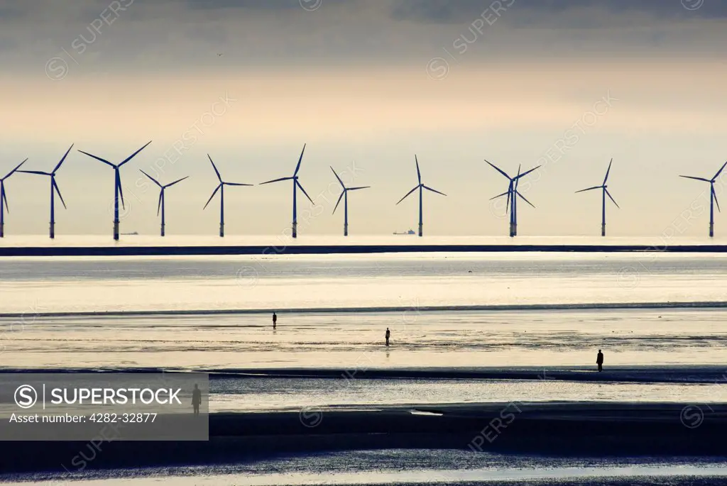 England, Merseyside, Crosby. Sculptures and wind turbines on a Liverpool beach.