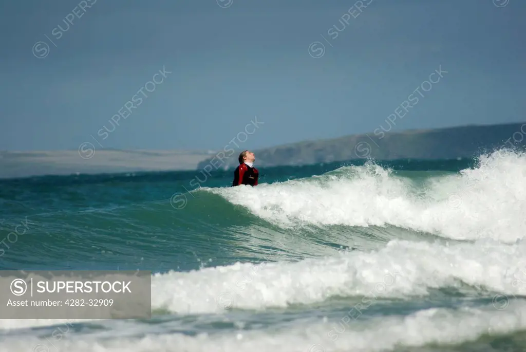 England, Cornwall, Newquay. Surfer riding a wave in Newquay.