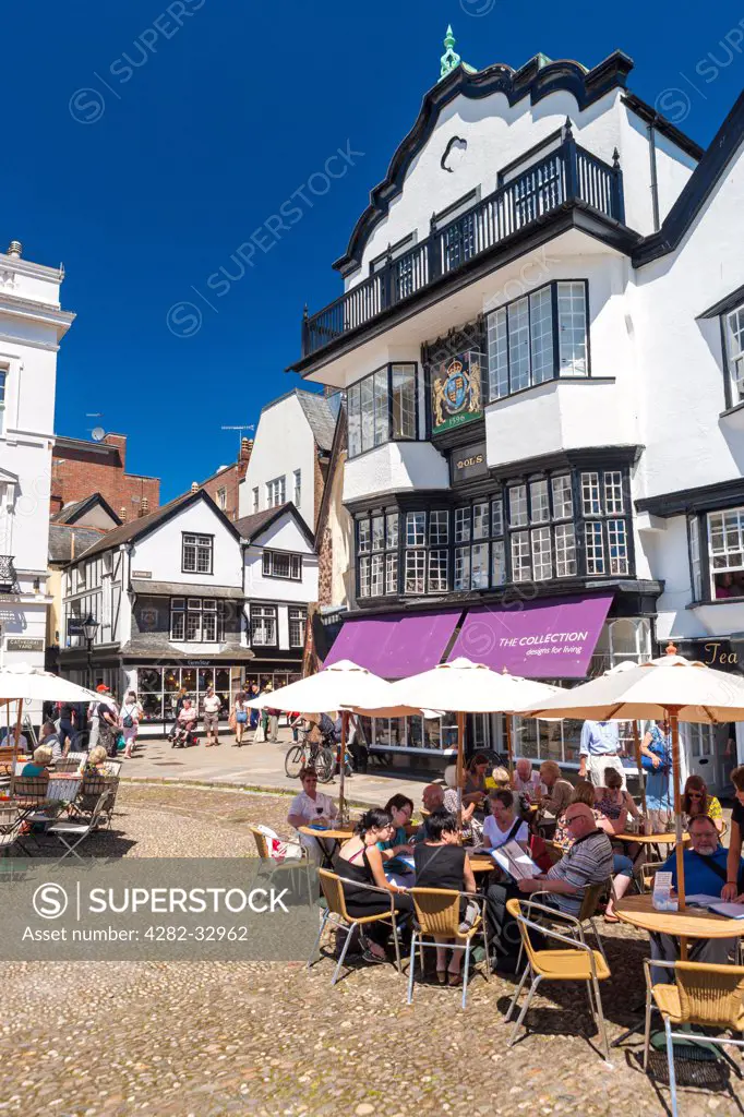 England, Devon, Exeter. People sitting at tables outside a coffee house in Cathedral Close.