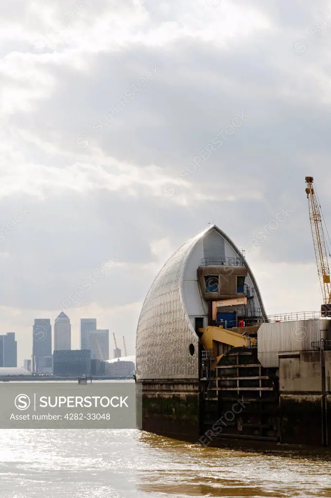 England, London, New Charlton. Detail of the Thames Barrier with Canary Wharf in the background.