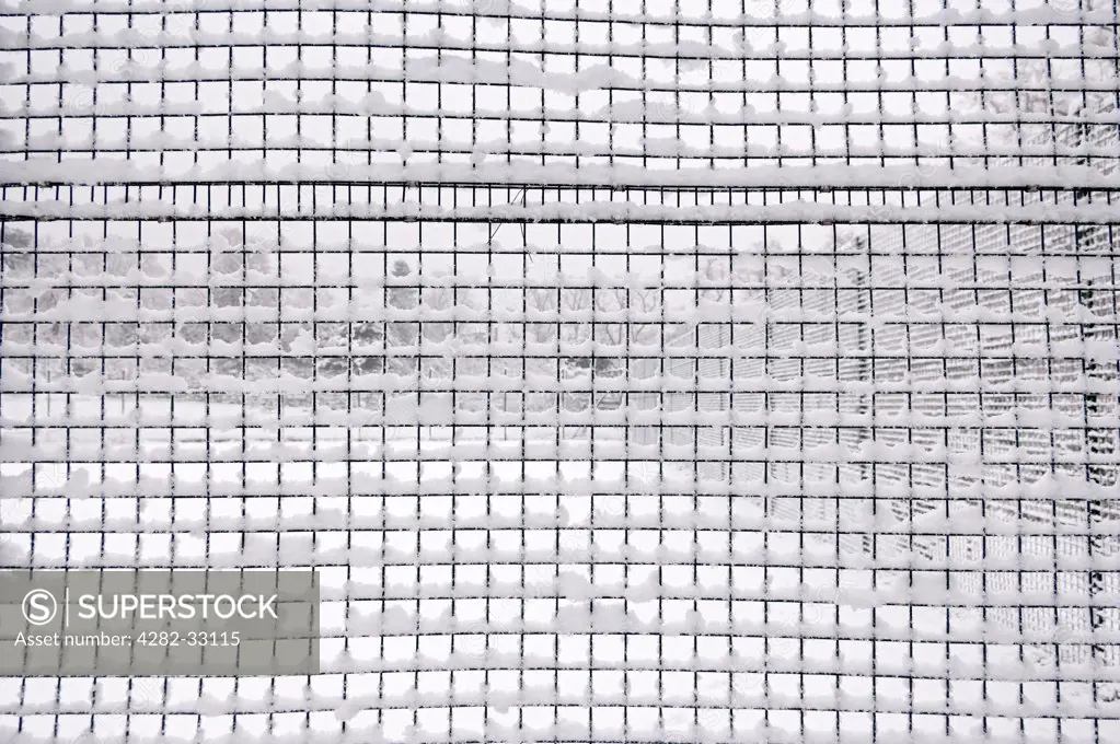 England, London, Camden. Snow-covered mesh fence in Waterlow Park in North London.