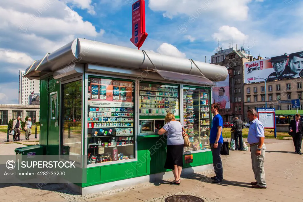 Poland, Mazovia Province, Warsaw. People at a typical kiosk selling tobacco and magazines in downtown Warsaw.