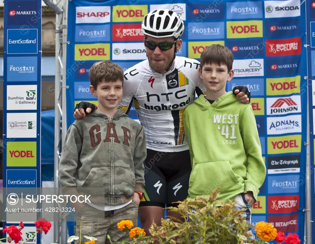 Scotland, Scottish Borders, Peebles. Mark Cavendish of Team HTC Highroad poses for a photograph with two young boys at the start of stage one of the 2011 Tour of Britain.