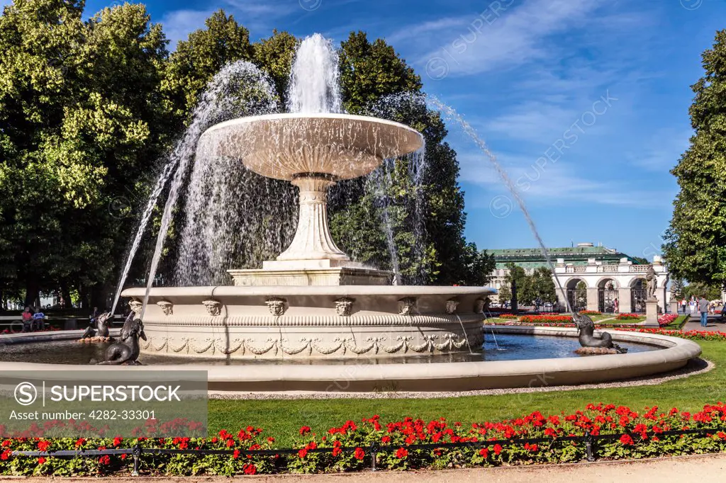 Poland, Mazovia Province, Warsaw. Fountain in Ogrod Saski in Warsaw with the Tomb of the Unknown Soldier in Pilsudski Square beyond.
