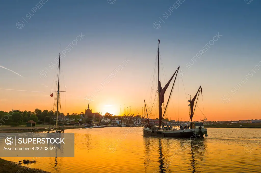 England, Essex, Maldon. The last Thames sailing barge returns at sunset to Maldon quay.