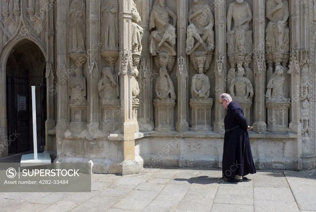 England, Devon, Exeter. An old clergyman in front of Exeter Cathedral.
