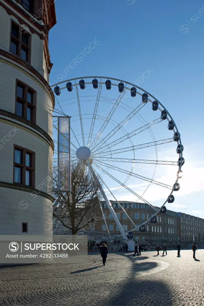 Germany, North Rhine Westphalia, Duesseldorf. A ferris wheel behind the Shipping Museum tower in Dusseldorf.