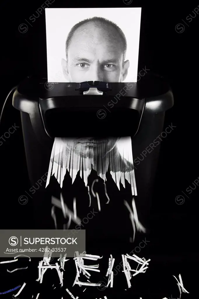 England, Gloucestershire, Forest of Dean. Photograph of a man's face being put through a paper shredder.