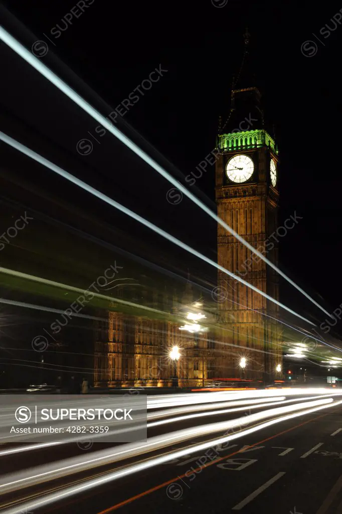 England, London, Westminster. Light trails from traffic crossing Westminster bridge by Big Ben and the House of Commons at night.