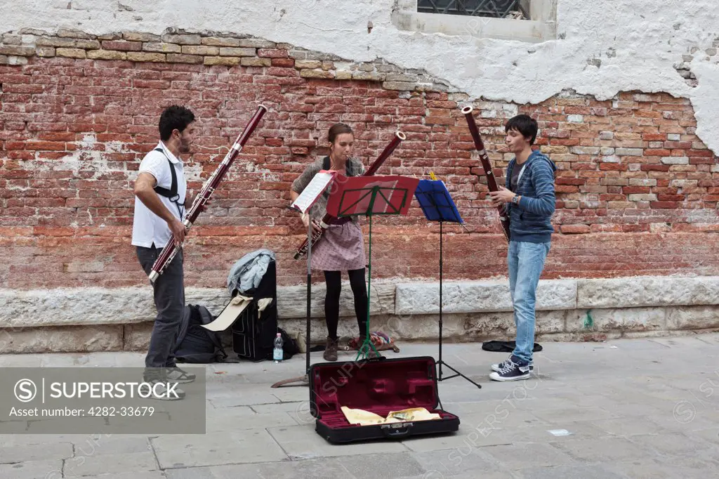 Italy, Venetto, Venice. Music students busking in the Accademia district of Venice.