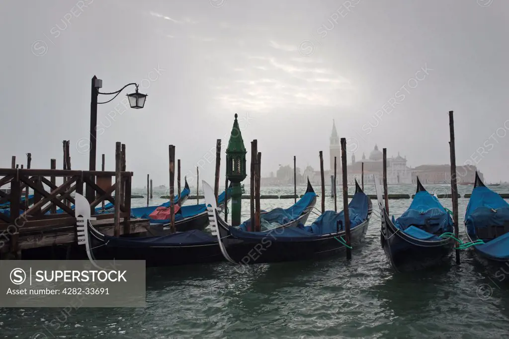 Italy, Venetto, Venice. Gondolas moored in the Lagoon on a misty morning in Venice.