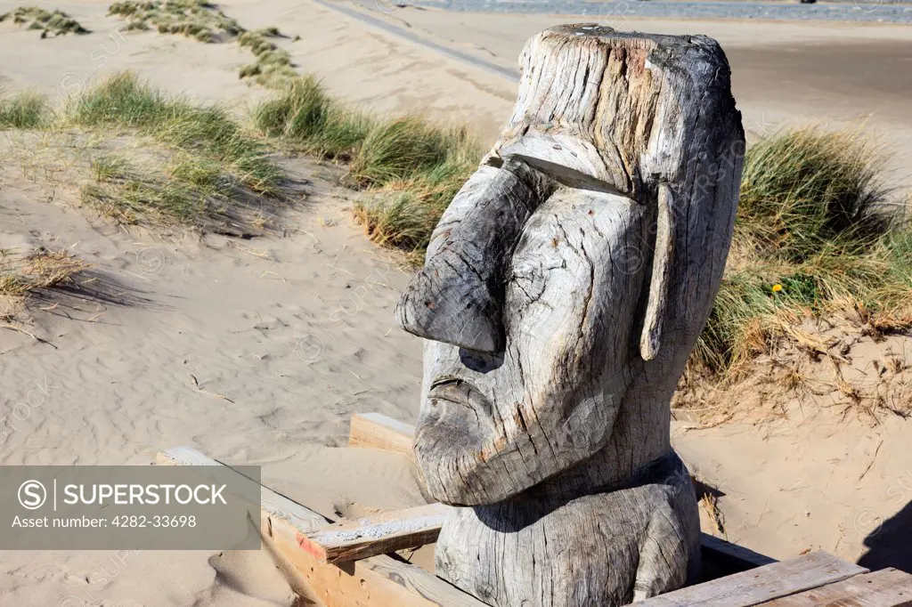 Wales, Gwynedd, Barmouth. A giant carved wooden head on Barmouth dunes.