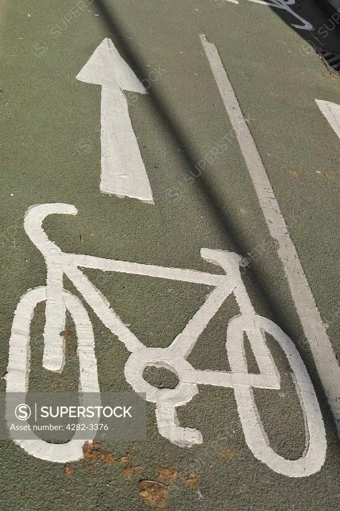 England, London, -. A white cycle graphic painted on a road indicating a cycle lane.