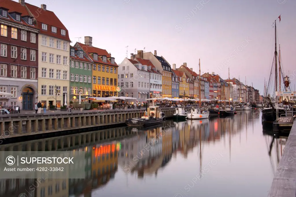 Denmark, Hovedstaden, Copenhagen. Boats and townhouses along the Nyhavn canal in Copenhagen.