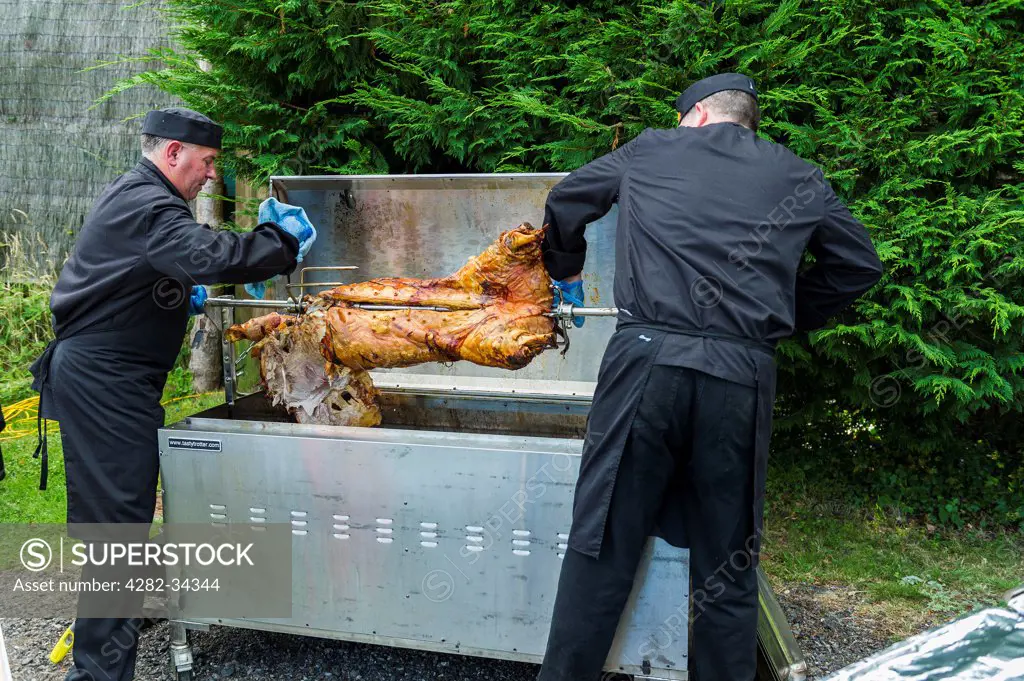 England, Cornwall, Looe. A hog roast being prepared for carving and serving.