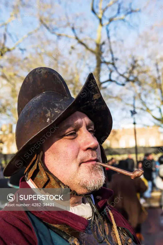 England, London, The Mall. A member of the English Civil War Society smokes a pipe before attending a service to commemorate the execution of King Charles I.