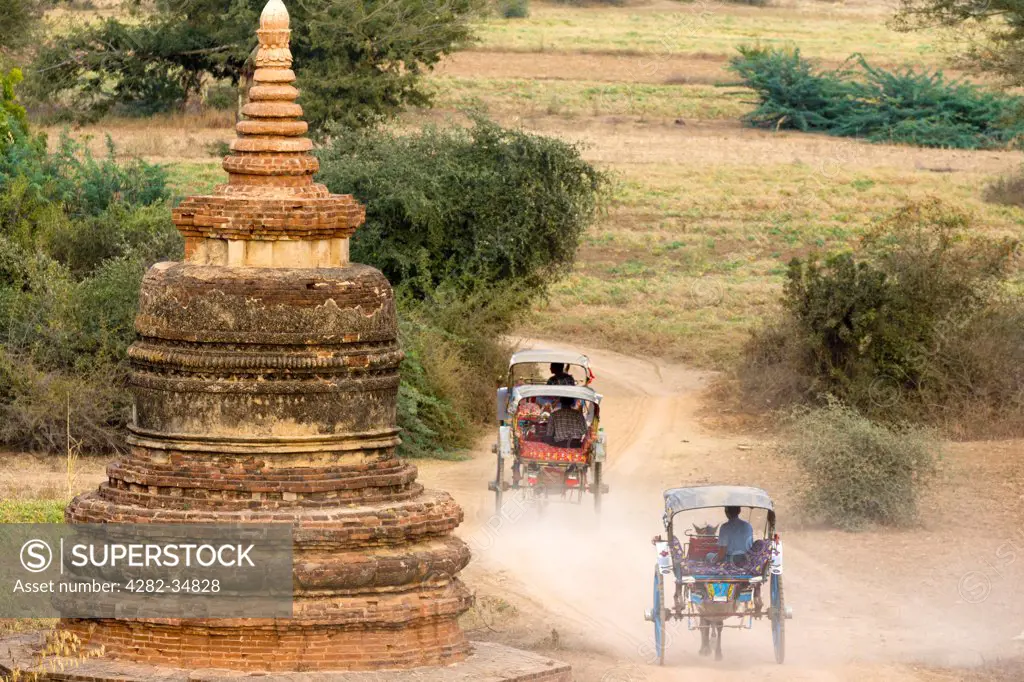 Myanmar, Mandalay, Bagan. Horse and buggies ride home at twilight amidst the stupas  in Bagan in Myanmar.