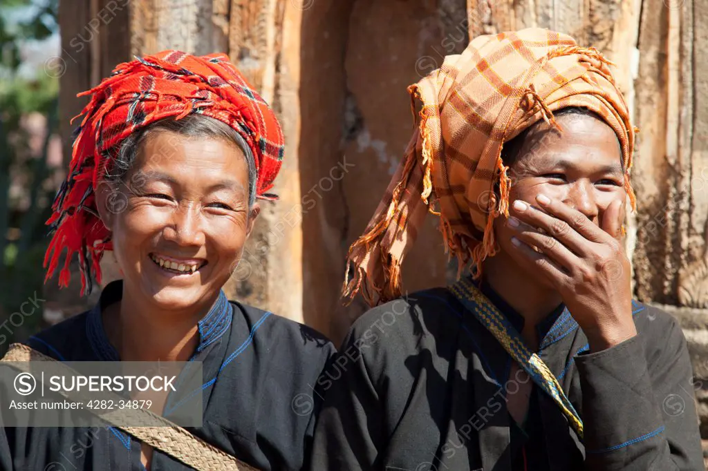Myanmar, Shan, Shwe Inn Thein. Two tribal women having a good laugh at the abandoned Inn Thein Pagoda Complex in Myanmar.