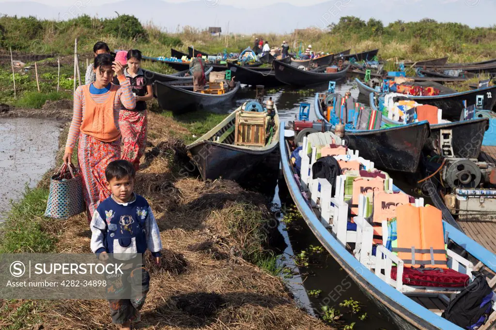 Myanmar, Shan, Lake Inle. Boat passengers disembarking for market day at a small village by Lake Inle in Myanmar.