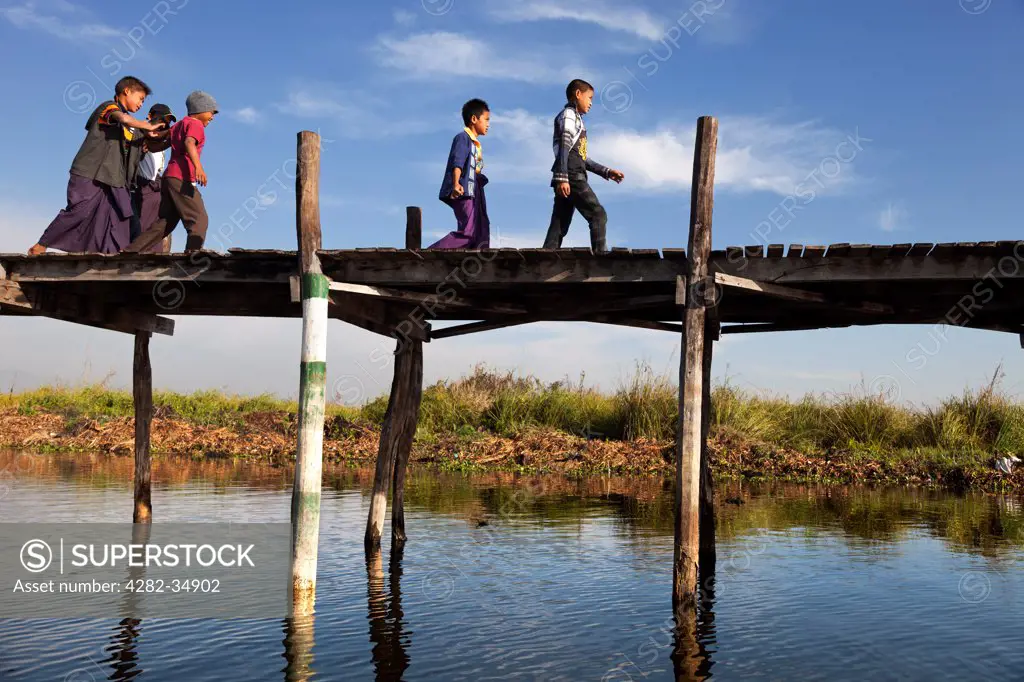 Myanmar, Shan, Lake Inle. Children on a jetty by Lake Inle in Myanmar.