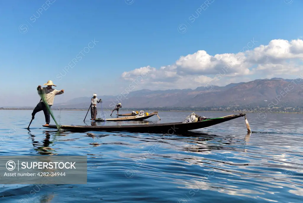 Myanmar, Shan, Lake Inle. Three fishing boats in a line on Lake Inle in Myanmar.