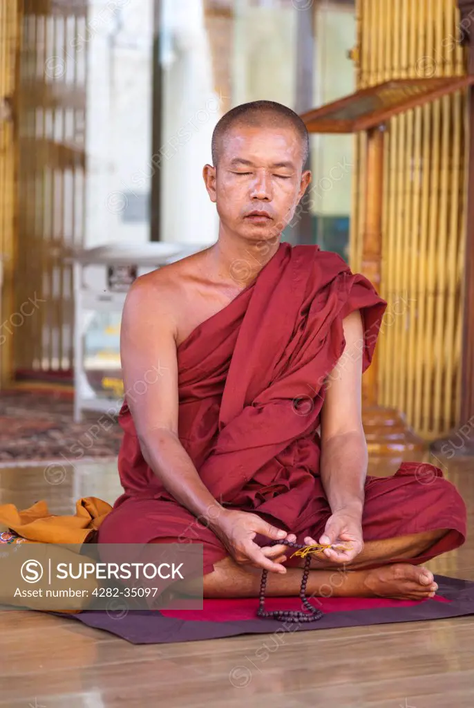 Myanmar, Yangon, Yangon. A meditating monk at the Shwedagon Pagoda in Yangon in Myanmar.
