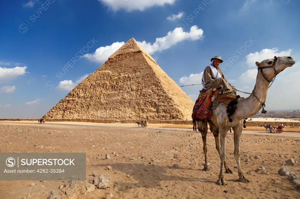 Egypt, Giza, Pyramids of Giza. A camel rider waiting in ambush for tourists at the Pyramids of Giza.