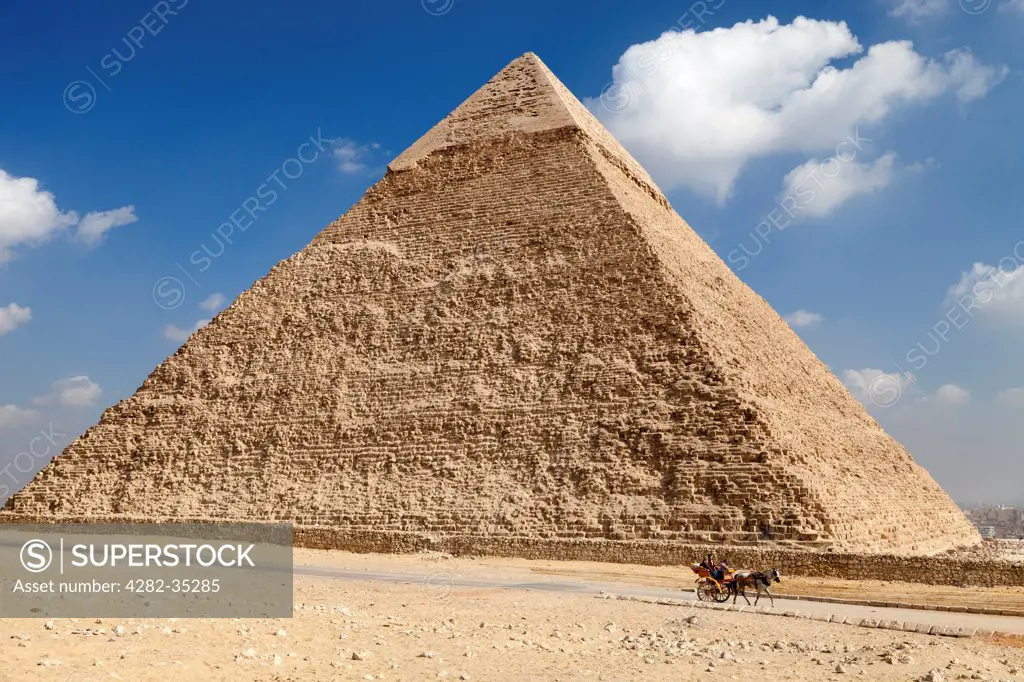 Egypt, Giza, Pyramids of Giza. A horse and trap passes the Khafre Pyramid in Giza.