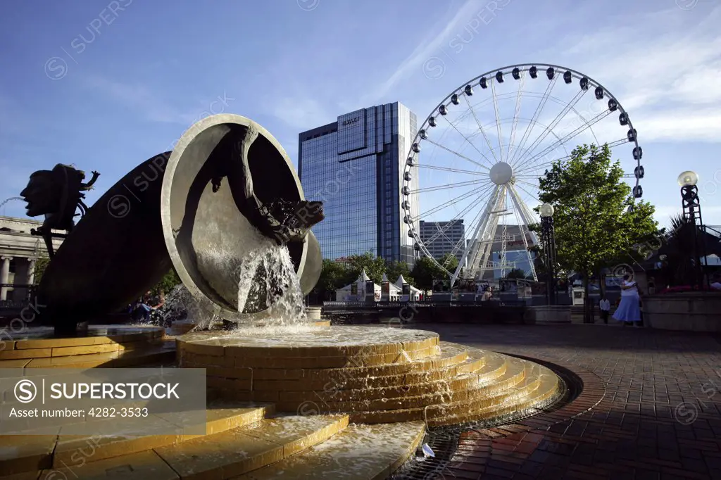 England, West Midlands, Birmingham. The water fountain in Centenary Square, with the Birmingham Wheel and Hyatt hotel to the rear. Centenary Square was named in celebration of the centenary of Birmingham achieving city status in 1889.
