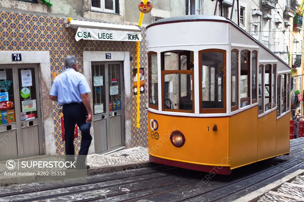 Portugal, District of Lisboa, Lisbon. Tram driver and traditional tram at Elevador da Bica in Bairro Alto.